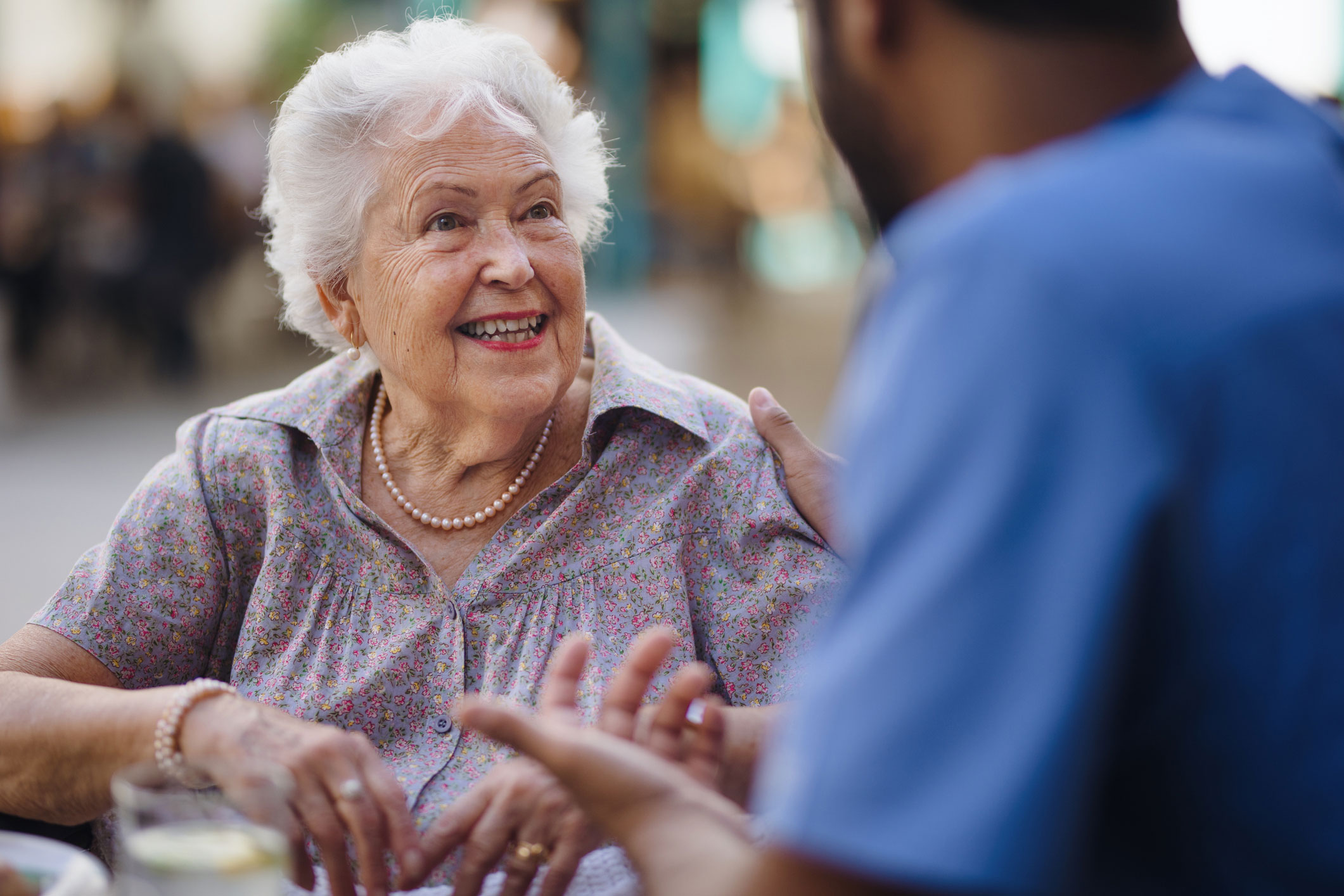 Senior woman smiling to a worker at long term care home.