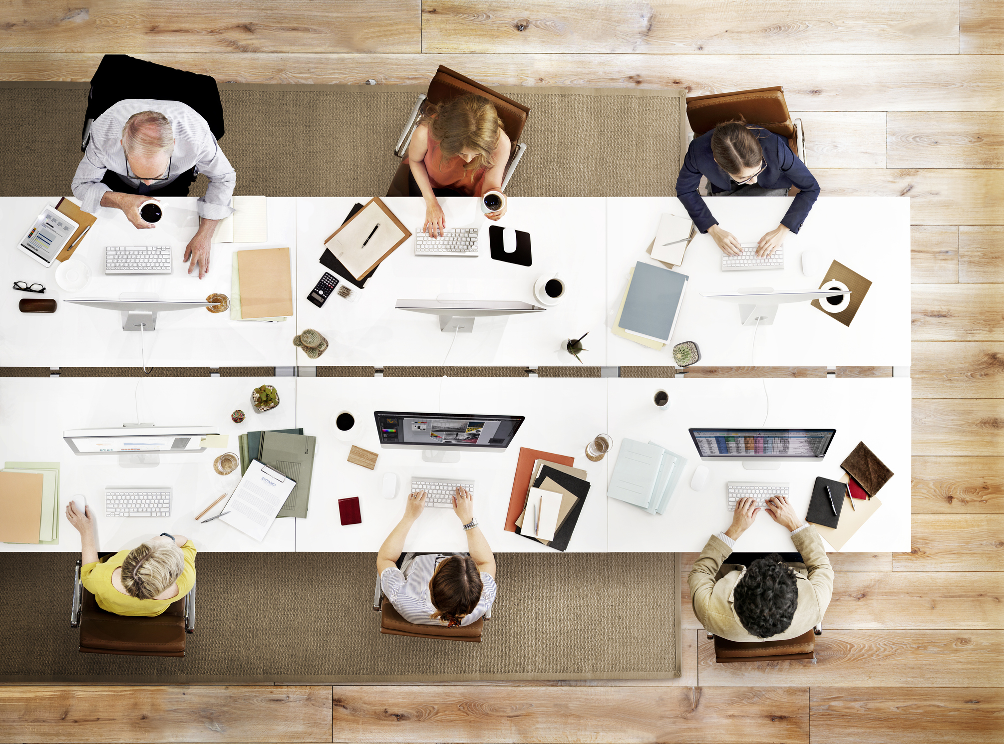 Overhead photo of people working around a table in a meeting.