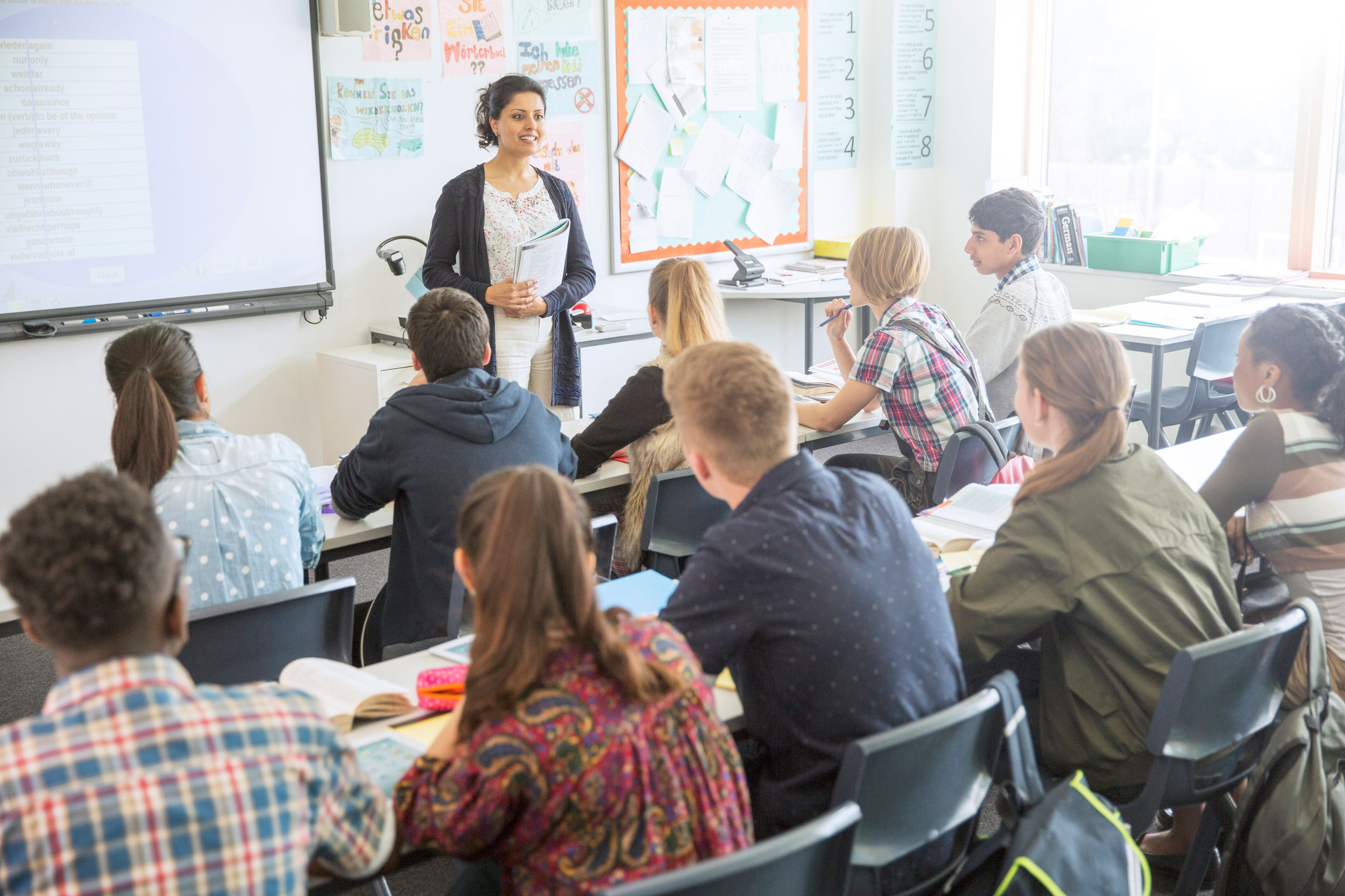 Students sitting in a classroom with teacher giving a lecture.